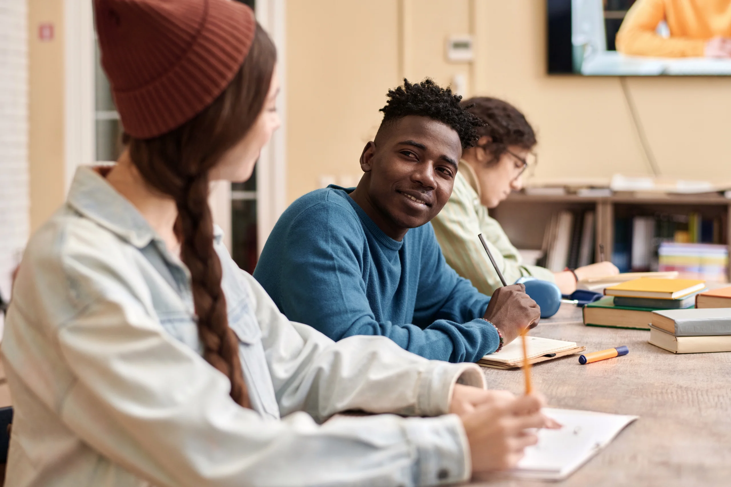 Jeune homme noir souriant pendant une étude de groupe