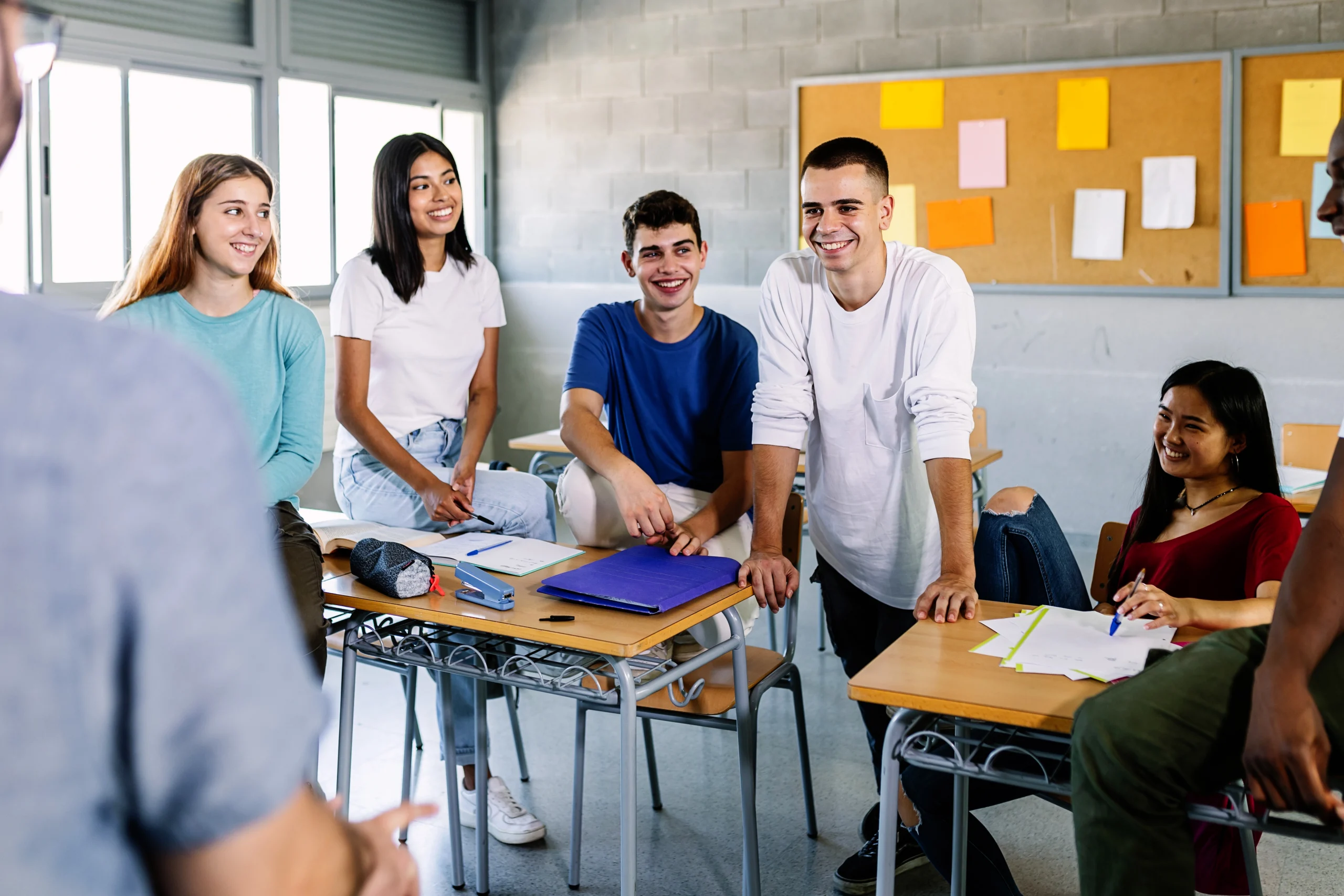 Professeur de sexe masculin et jeunes élèves adolescents discutant pendant une pause en classe